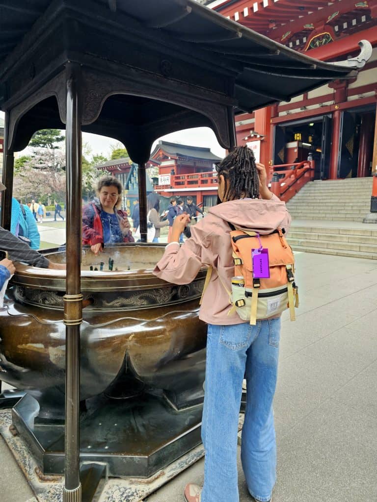 Visitante junto al gran incensario del templo Senso-ji en Asakusa, una de las tradiciones más conocidas del recinto