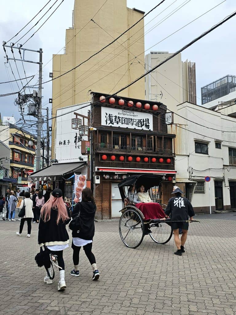 Calle de Asakusa con un rickshaw tradicional y ambiente típico del barrio histórico de Tokio