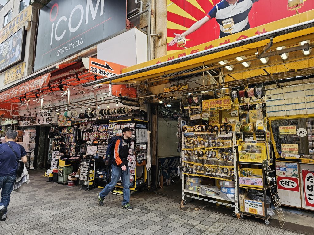 Tienda de electrónica y componentes en Akihabara con cables, piezas y accesorios expuestos en la calle